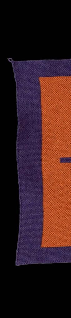 Zu sehen ist das erste Stück des Typo-Strick Schals in den Farben lila und orange.